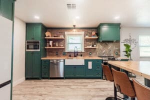 Modern kitchen with green cabinets and island.