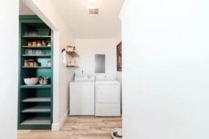 Laundry room with shelves and appliances.