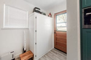 Laundry room with wooden door and appliances.