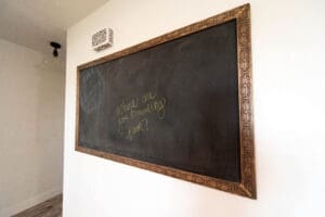 Framed blackboard with handwritten yellow text.