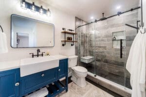 Modern bathroom with blue vanity and shower.