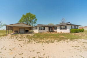 Ranch-style house with attached carport and yard.