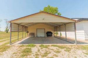 Metal carport with grill and bench.