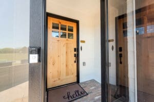 Wooden front door with "hello" doormat.
