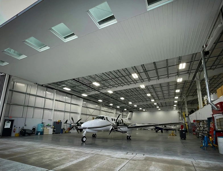 A hangar with several airplanes parked in it.