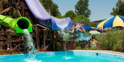 A person jumping in the air over an outdoor pool.