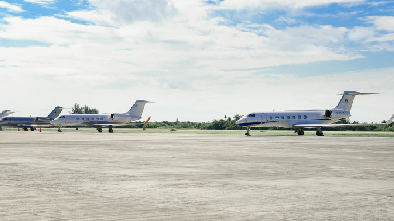 Two airplanes are parked on a runway.